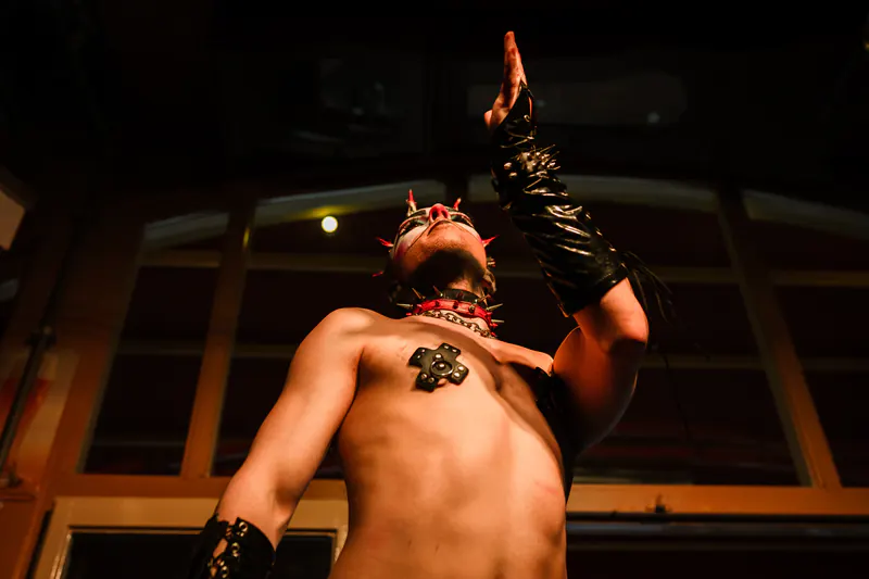 Performer die een gehandschoende arm opheft op het podium in warm licht