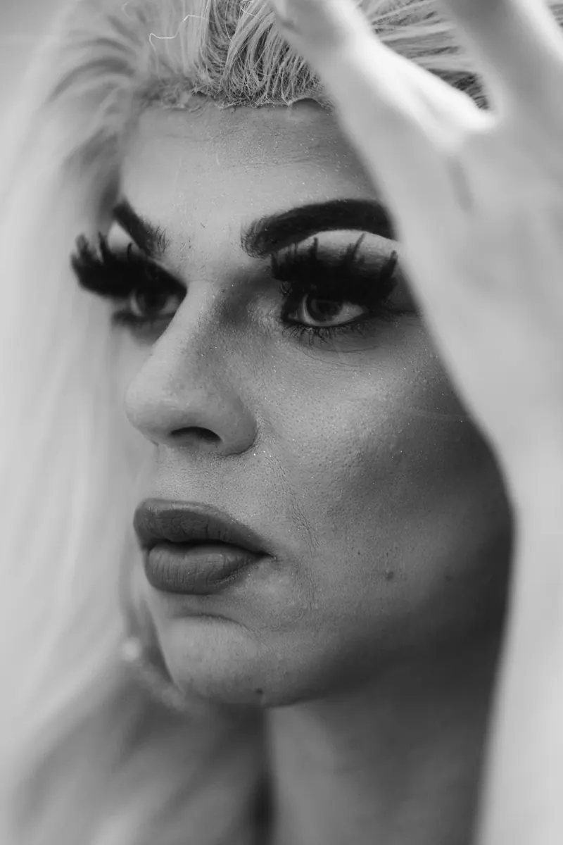 Close-up van een drag queen met dramatische wimpers, zwart-wit
